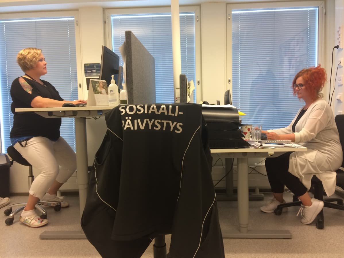 Kaksi naista työpöytiensä ääressä Tampereella Sorinkadun sosiaalipäivystyksessä.