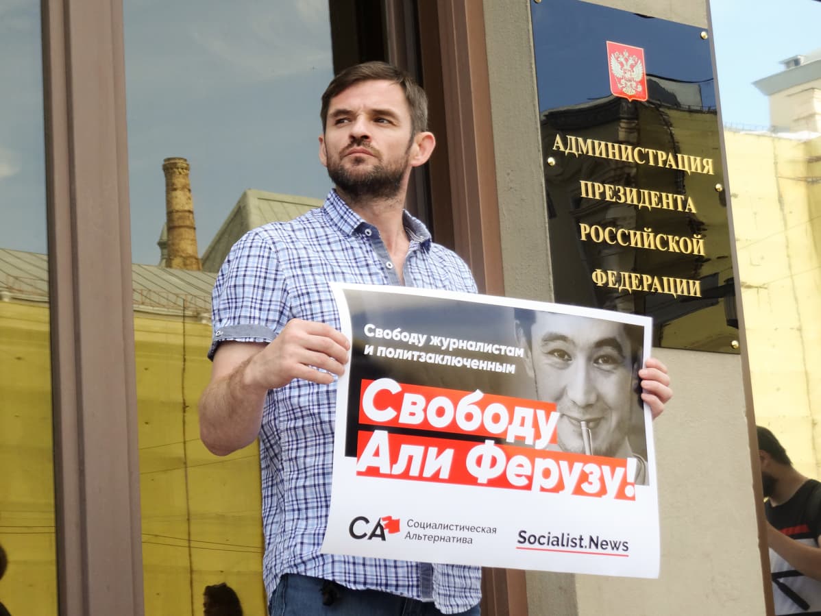 Jevgeni Pavlovski osoittaa mieltä Ali Feruzin puolesta presidentinhallinnon ovella.