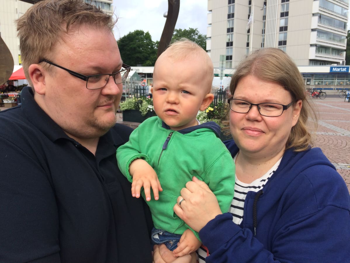 Perhe torilla, isä ja äiti 1v 7 kk lapsi sylissään. Isä Riku, äiti Kaisu, lapsi Akseli