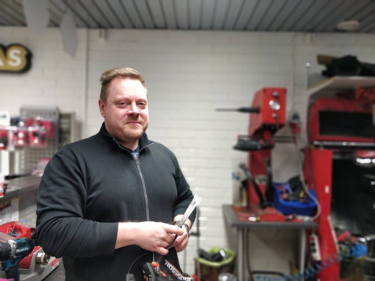 Suutari Antti Rautiainen esittelee kenkiä, joihin on laittamassa nastoja.