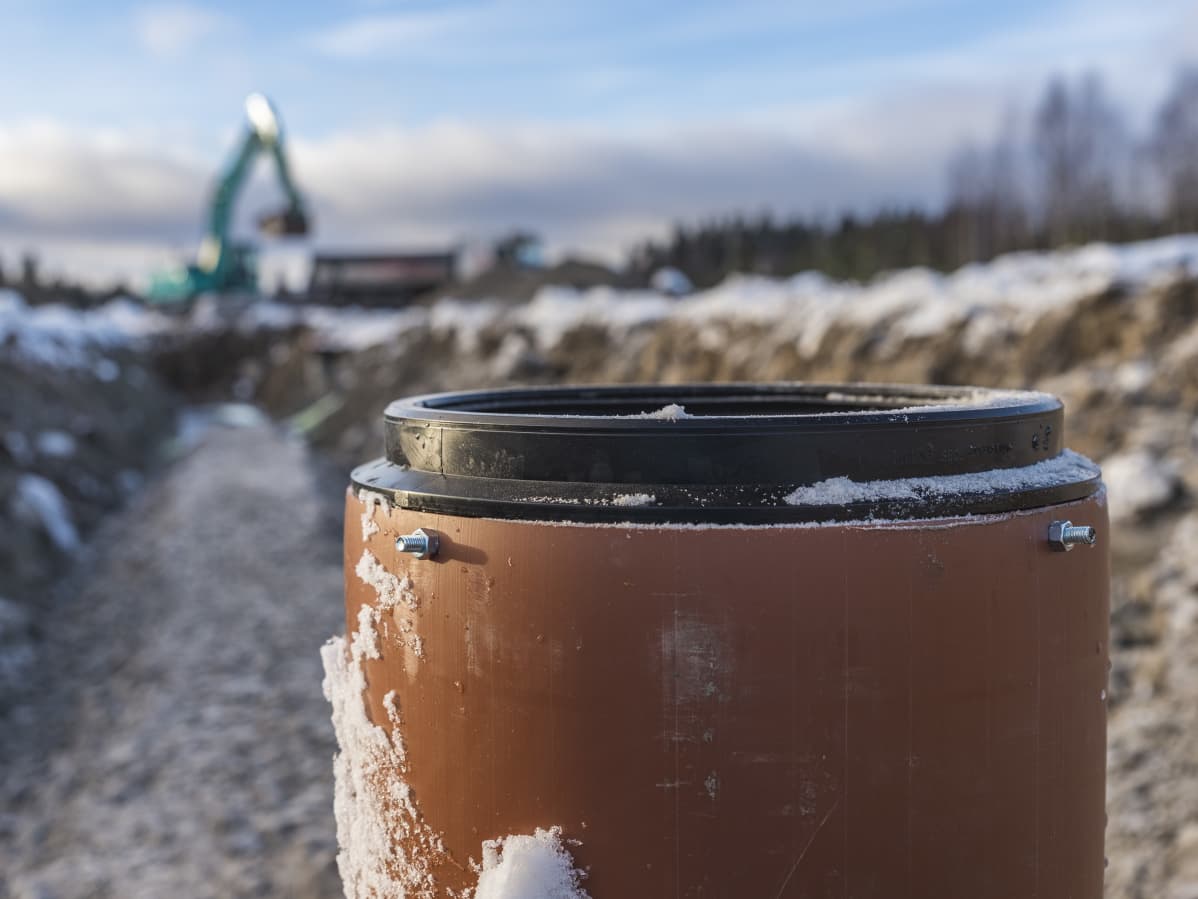 Kaivinkoneet kaivavat putkia maahan.