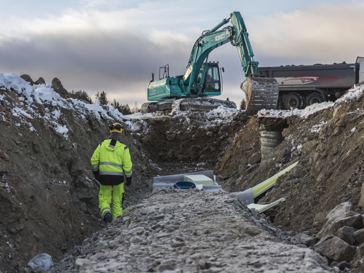 Kaivinkoneet kaivavat putkia maahan.