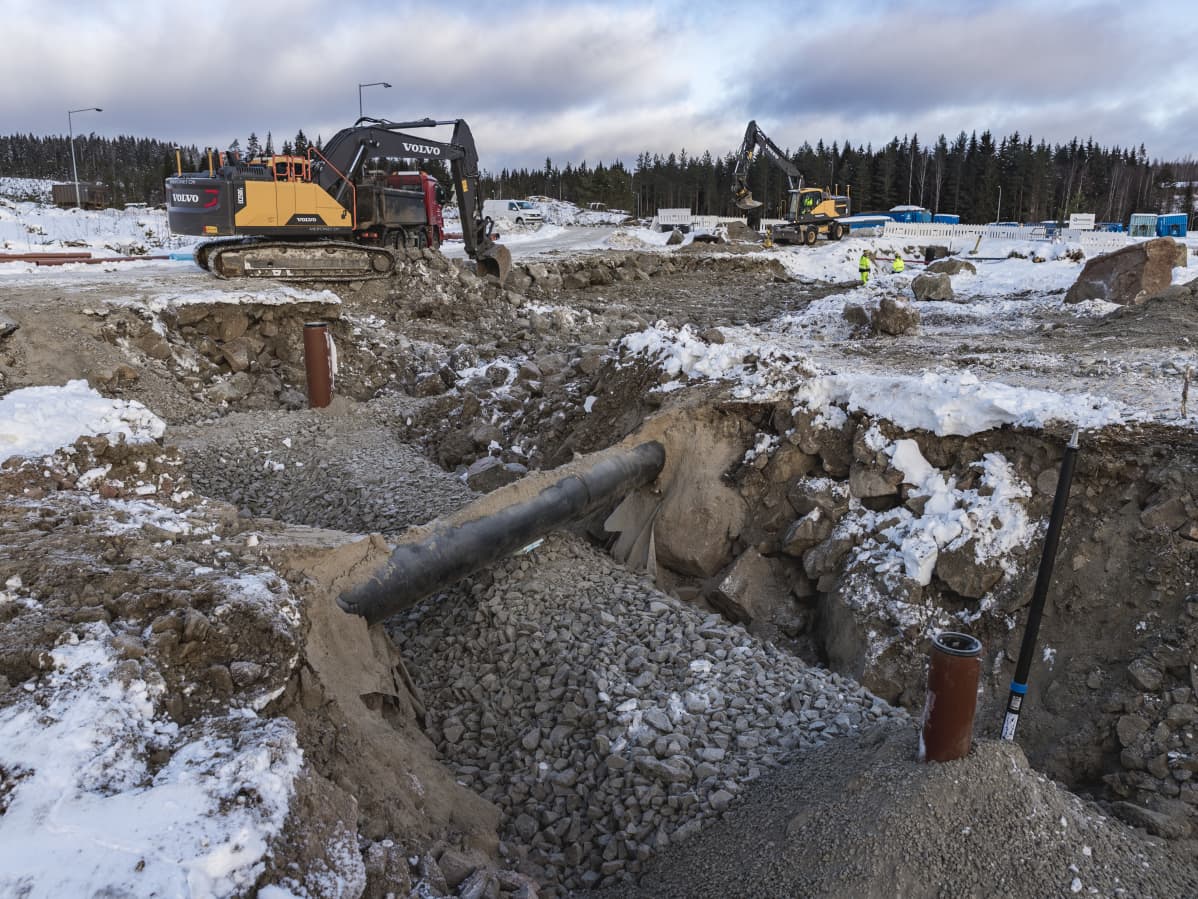 Kaivinkoneet kaivavat putkia maahan.