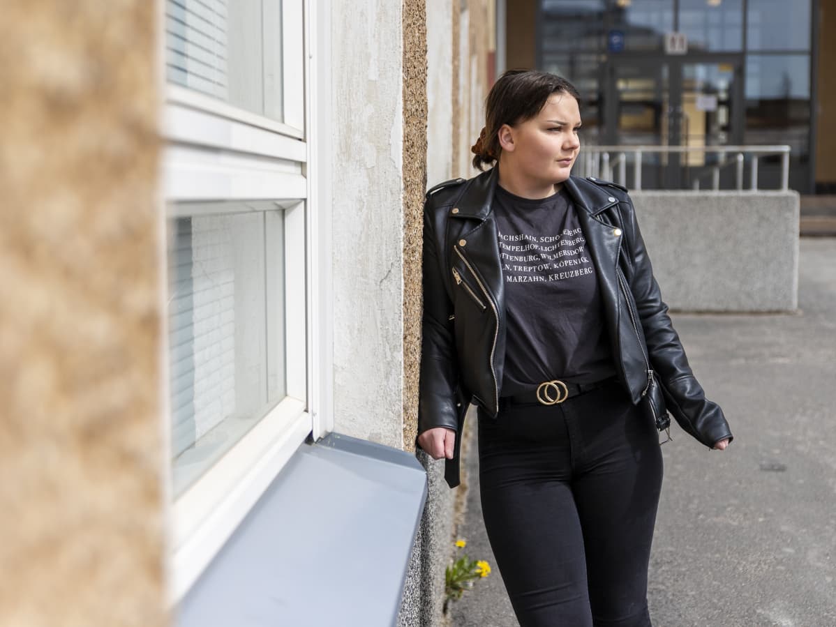 Jessica Kaatinen nojaa koulun seinään.