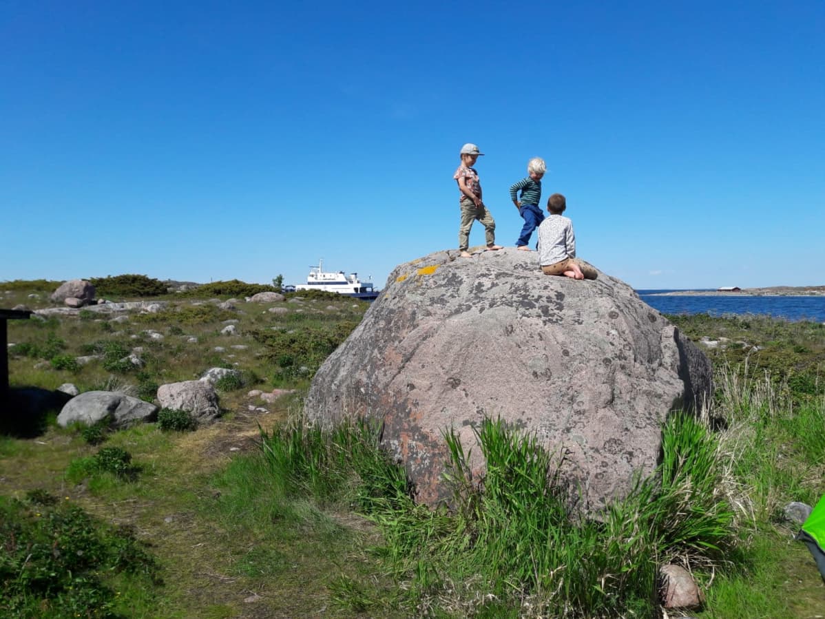 Lapset leikkivät kivellä Jurmossa meren äärellä.