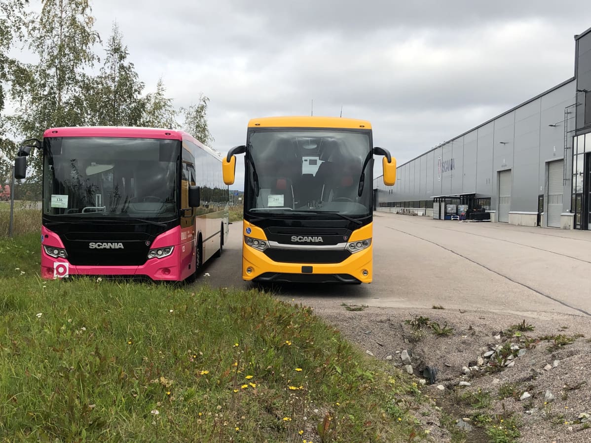 Kaksi linja-autoa yrityksen pihalla.