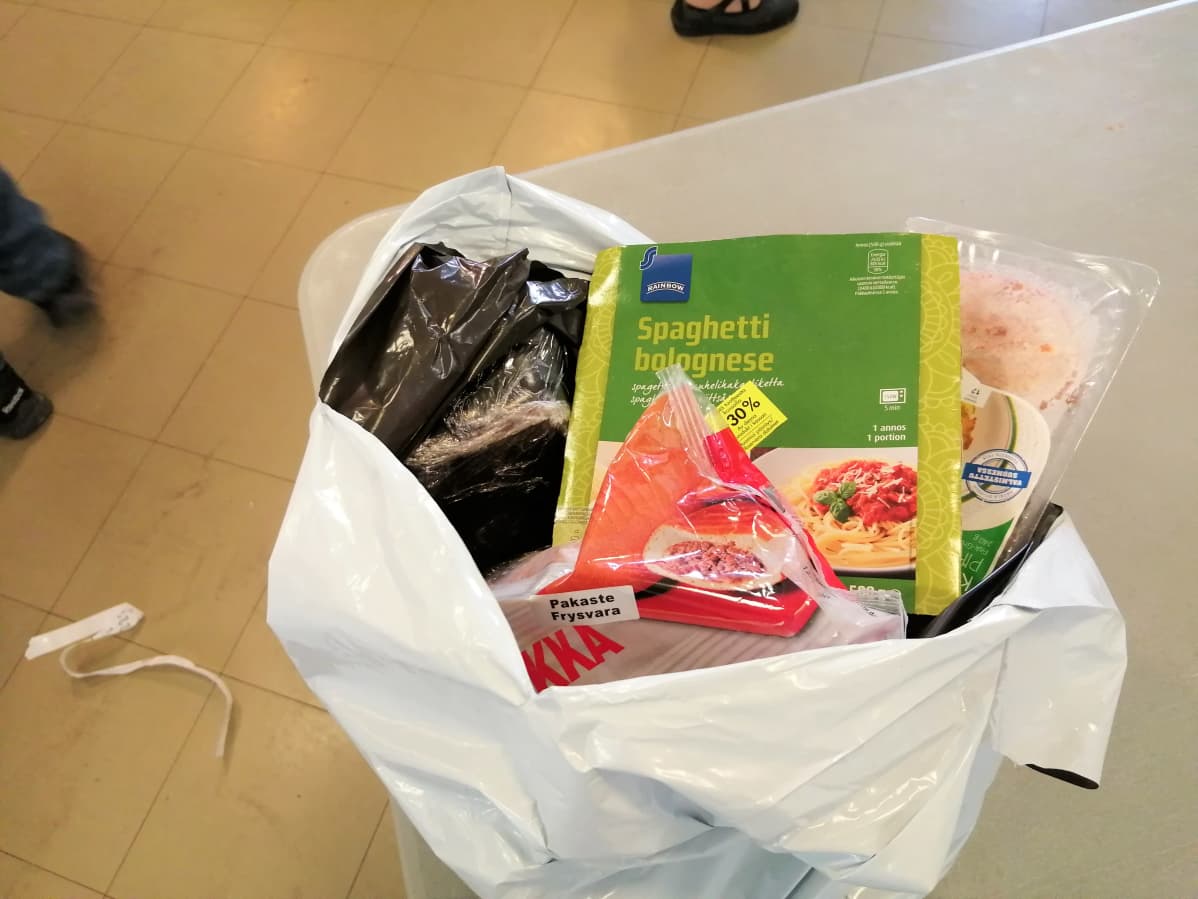 Vaasan ruoka-apuyhdistys pakkaa ruokaa kasseihin, kuvassa pakattu kassillinen valmisaterioita ja leikkeleitä.
