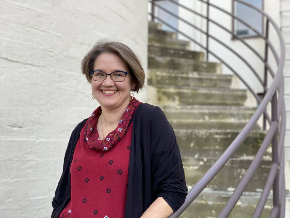 Tuulia Nicholls seisoo ulkona rappusilla.