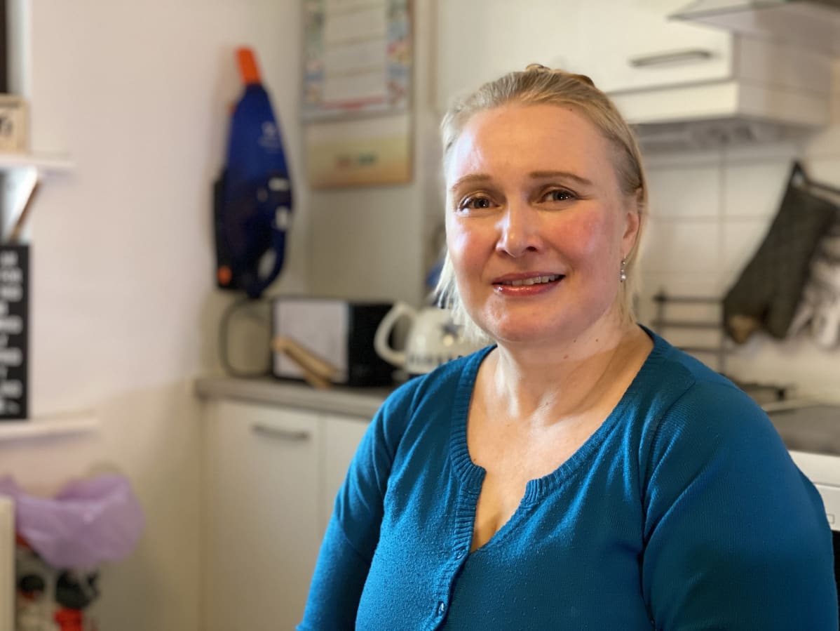 Anne Christiansen istuu keittiönpöydän ääressä.