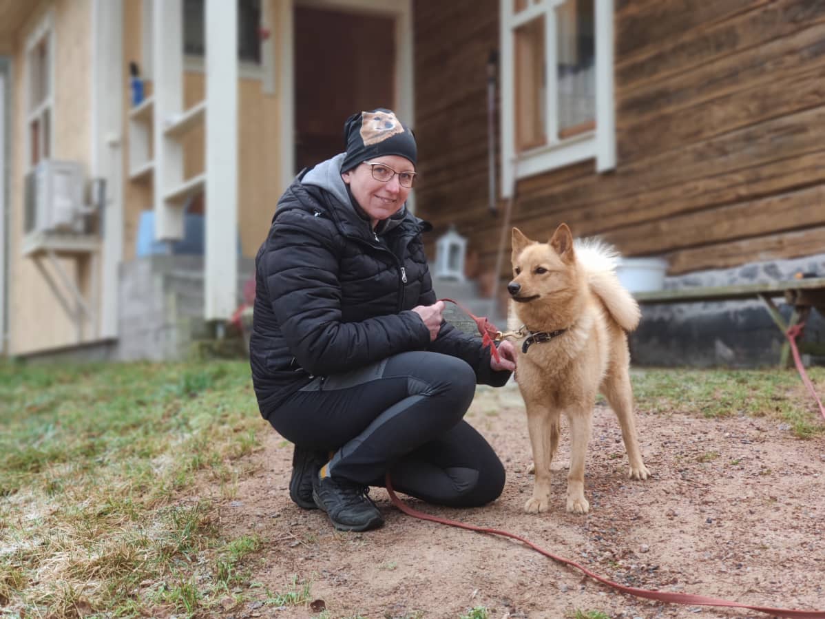 Tanja Raivio pihamallaan suomanpystykorva Lulun kanssa.