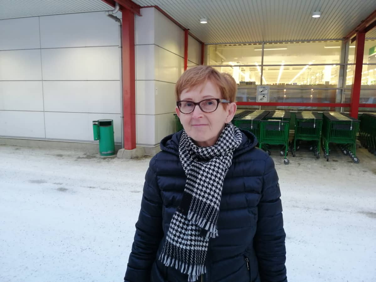 nainen marketin parkkipaikalla.