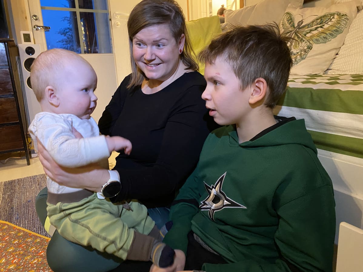 Annen sylissä istuva Aatos-vauva tuijottaa isoveli-Topia silmiin.