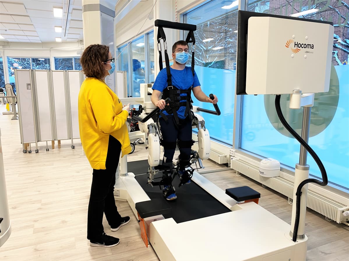 Premius kuntoutuksen fysioterapeutti Heidi Haromo ohjaa 19-vuotiasta Arttu Lageria kävelyrobottiin Premiuksen tiloissa Kalevassa.