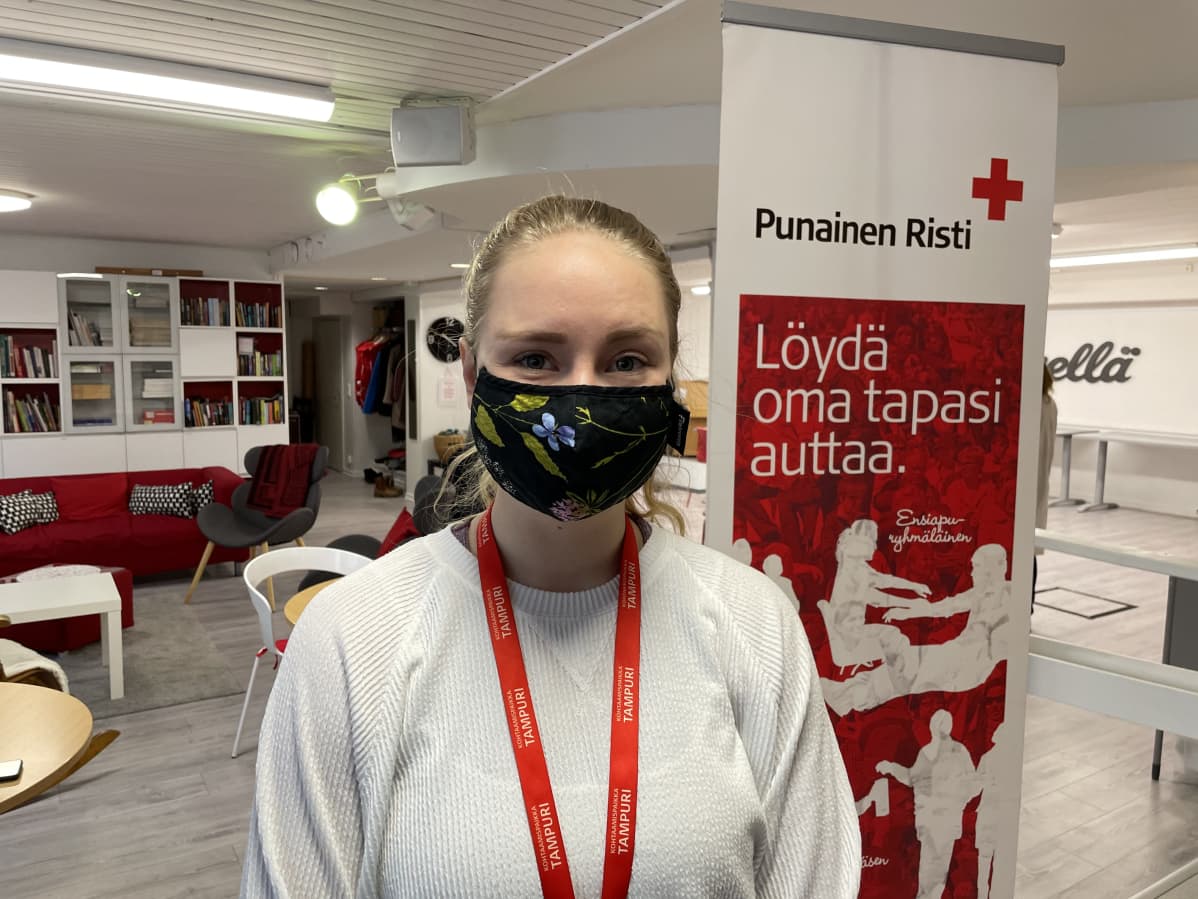 Nainen hymyilee maski kasvoillaan SPR:n Tampurin tiloissa Tampereella.