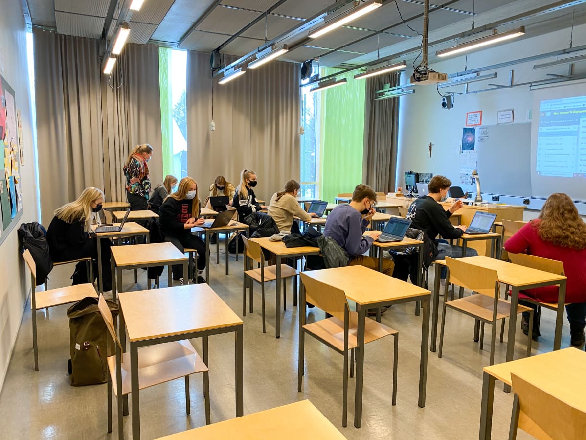 Opiskelijat istuvat luokkahuoneessa, maskit kasvoillaan.