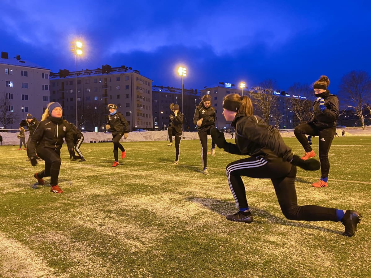HJK:n 06 akatemiajoukkueen nuoret lämmittelevät pimenevässä illassa Töölön pallokentällä.