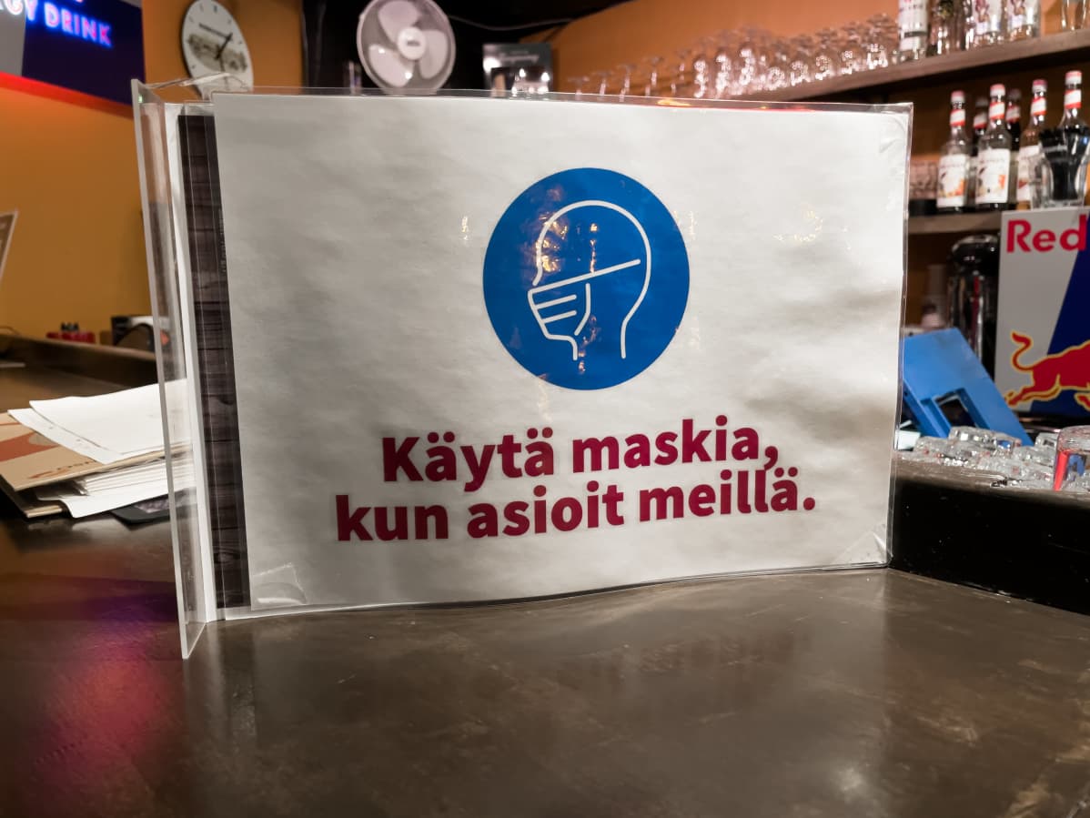 Bar Q -ravintolassa Imatralla koronarajoitus -kylttejä sisällä. "Käytä maskia, kun asioit meillä."