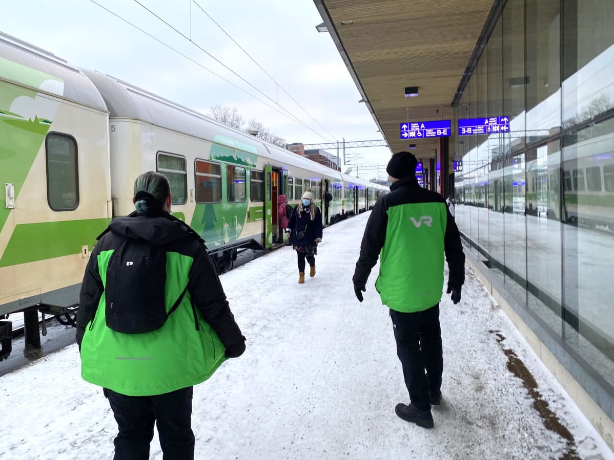 VR:n työntekijöitä ja matkustaja asemalaiturilla Lahdessa.