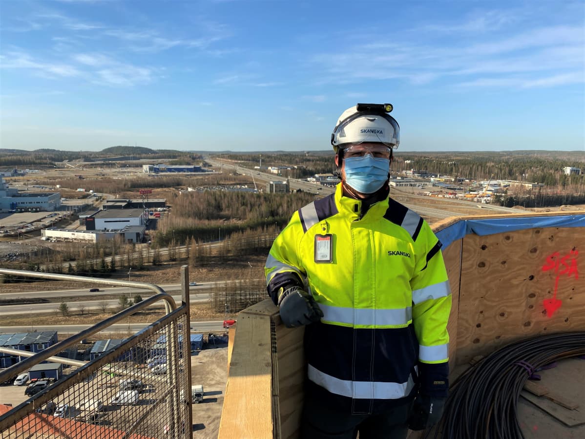 Skanskan aluevastaava Mikael Vuorijärvi. Sulkavuoren poistoilmapiipputyömaa 19. huhtikuuta 2021. Piippu on 44 metrin korkeudessa.