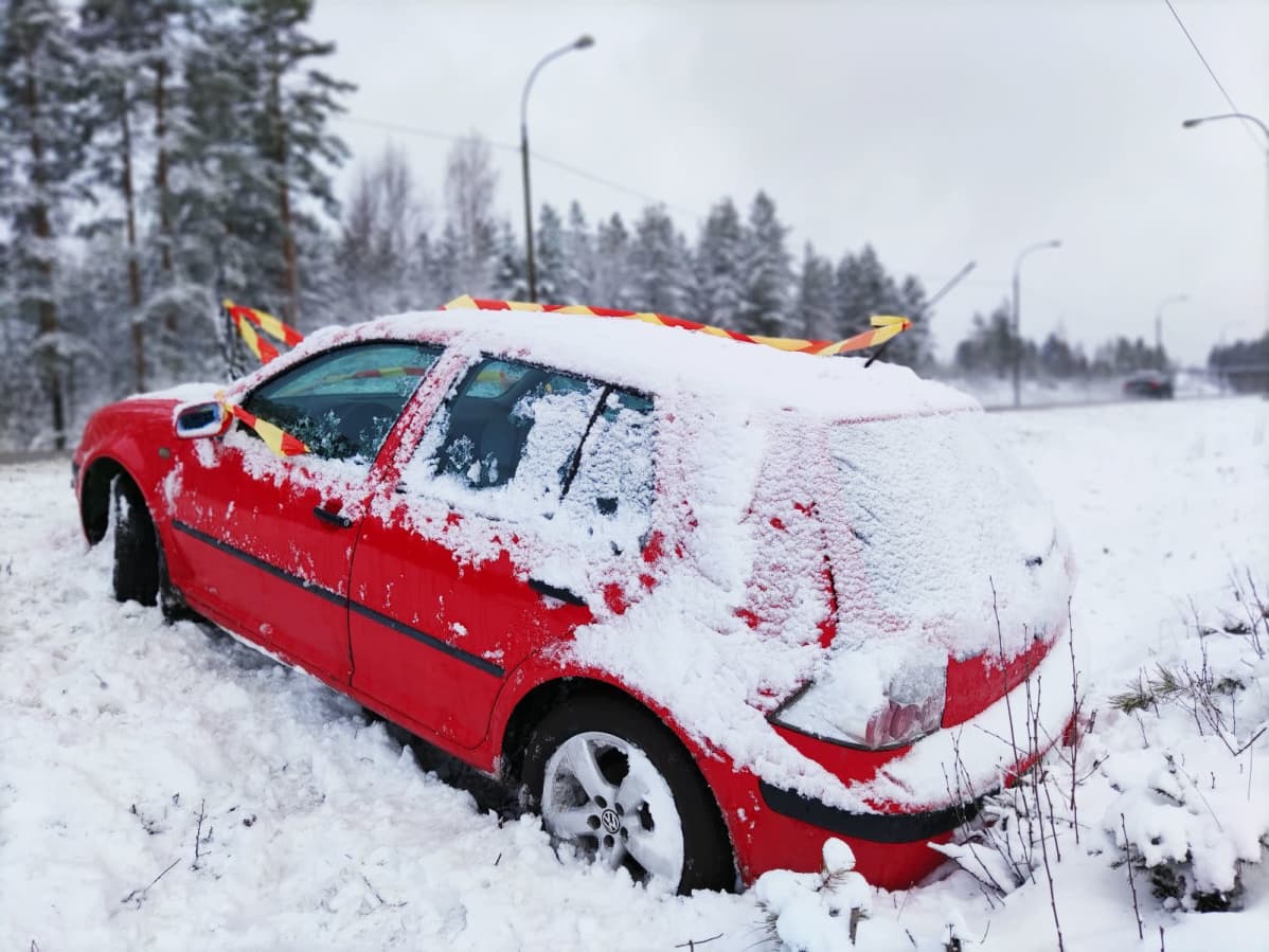 Auto ojassa Lehmon rampin lähellä Kuutostiellä. Ympärillä lunta.
