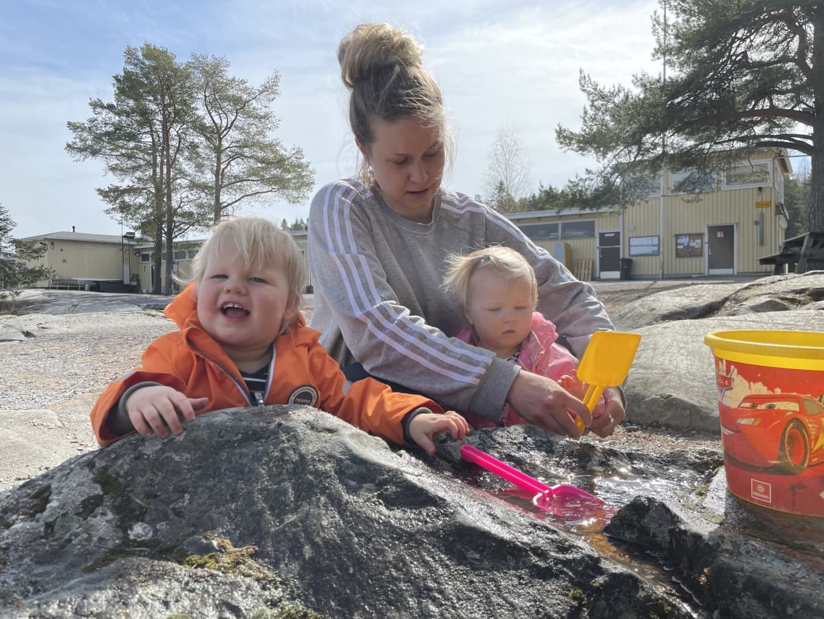 Annika Kuronen lastensa kanssa hiekkaleikeissä.