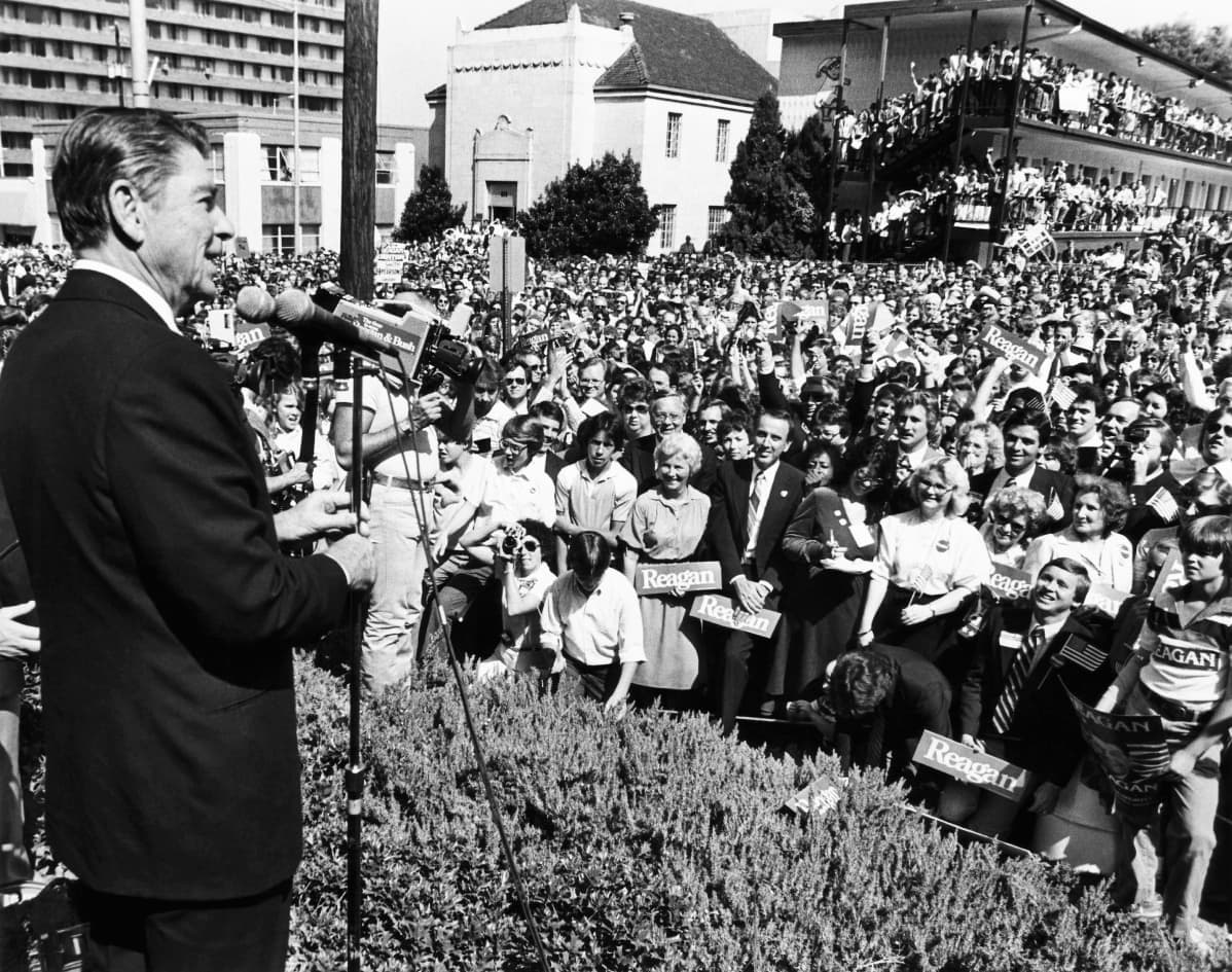 Mustavalkokuvassa Ronald Reagan puhuu yleisölle.