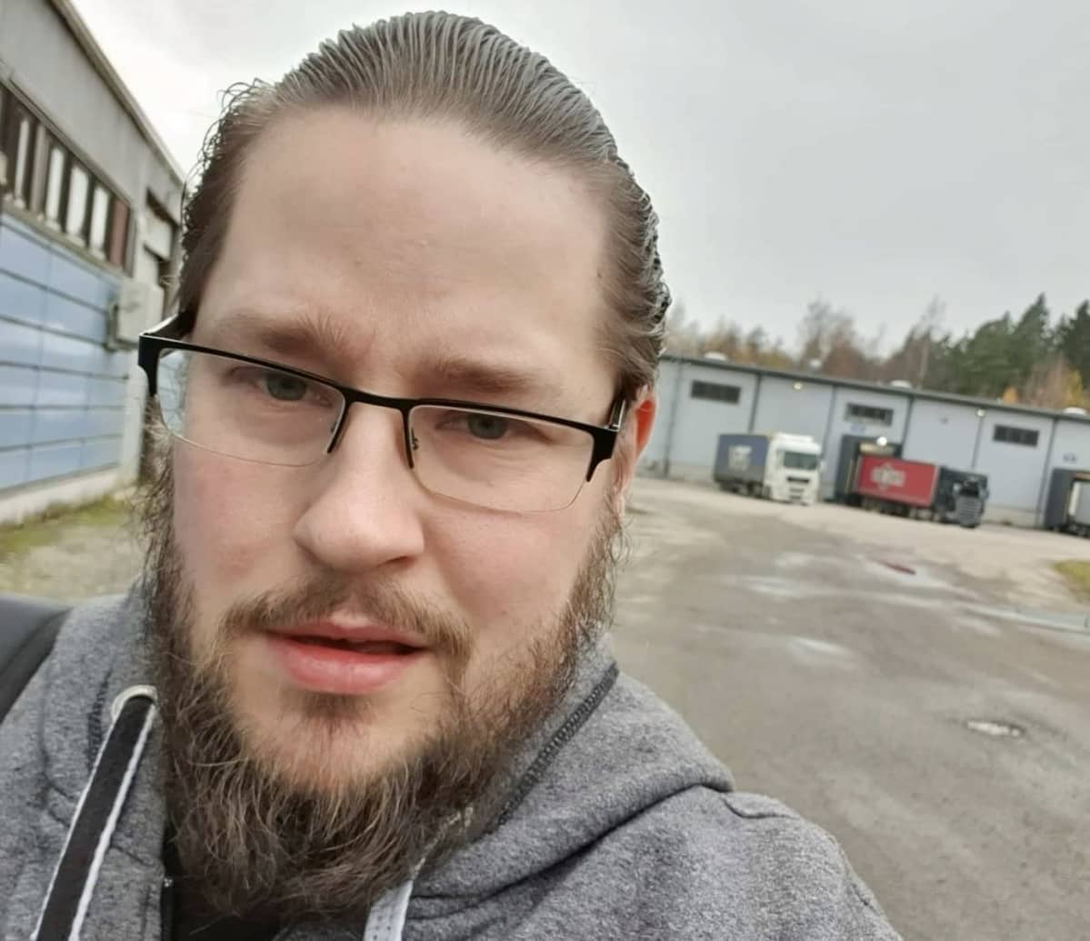 Nuori, parrakas mies katsoo kameraan lähikuvassa