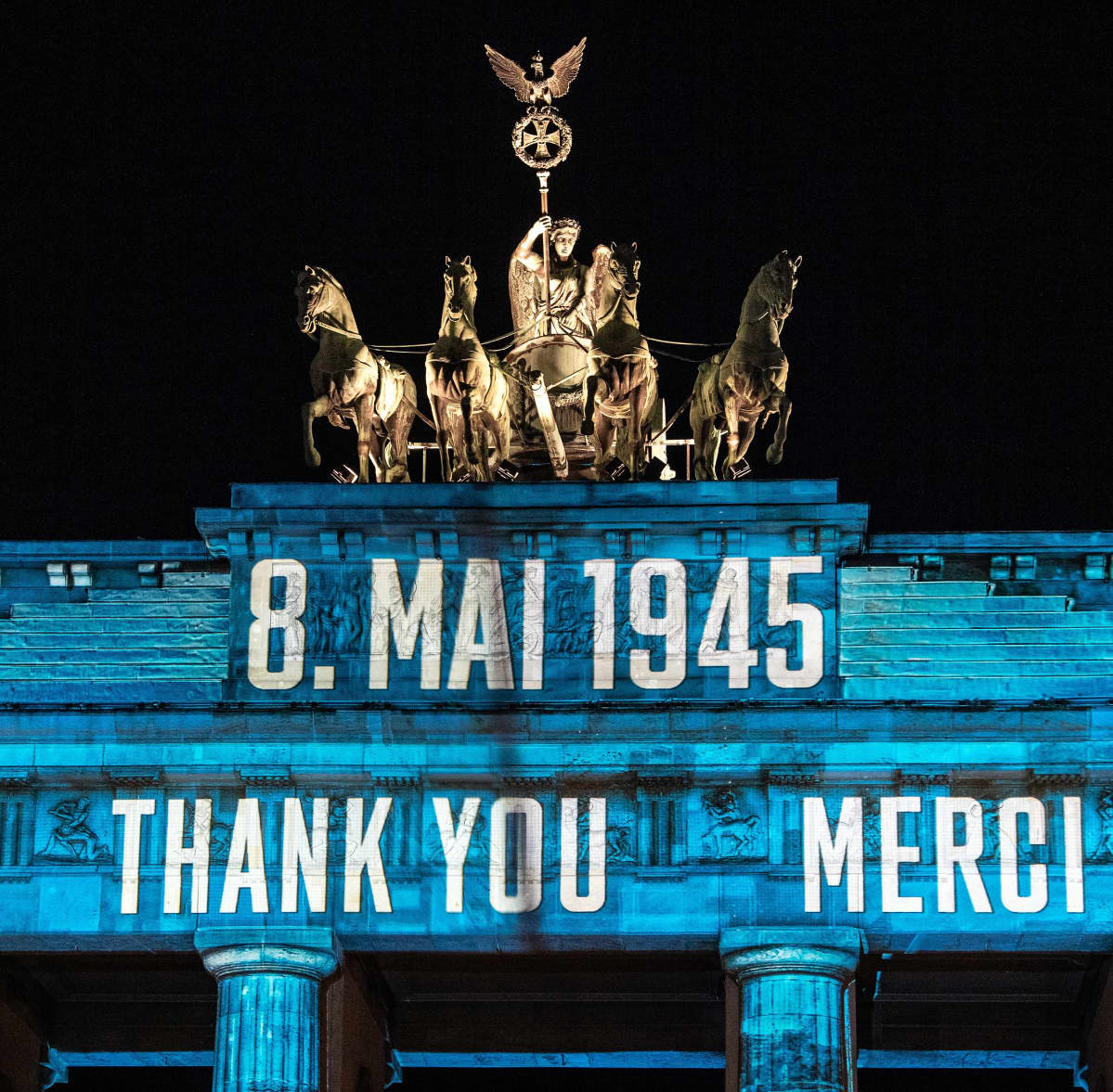 Brandenburgin porttiin on heijastettu teksti 8. Mai 1945 ja sen alla kiitoksia eri kielillä. Kuvassa näkyy englanniksi THANK YOU ja ranskaksi MERCI.