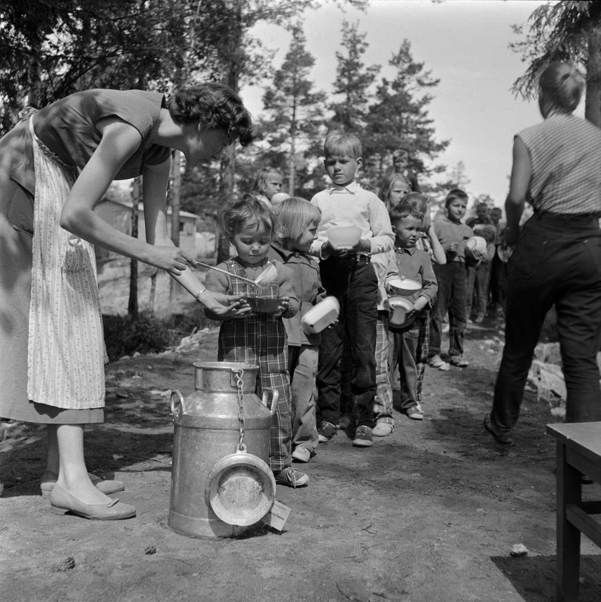 1950-luku, lapsia jonottamassa ruokaa leikkipuistossa.