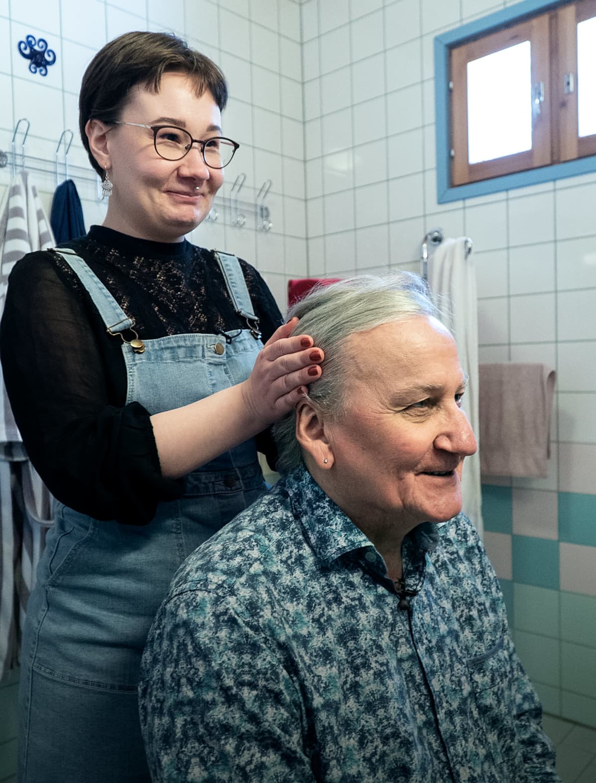 tytär laittaa isänsä hiuksia