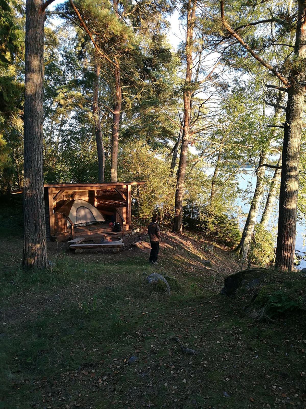 Teltta katoksessa ja mies rannalla