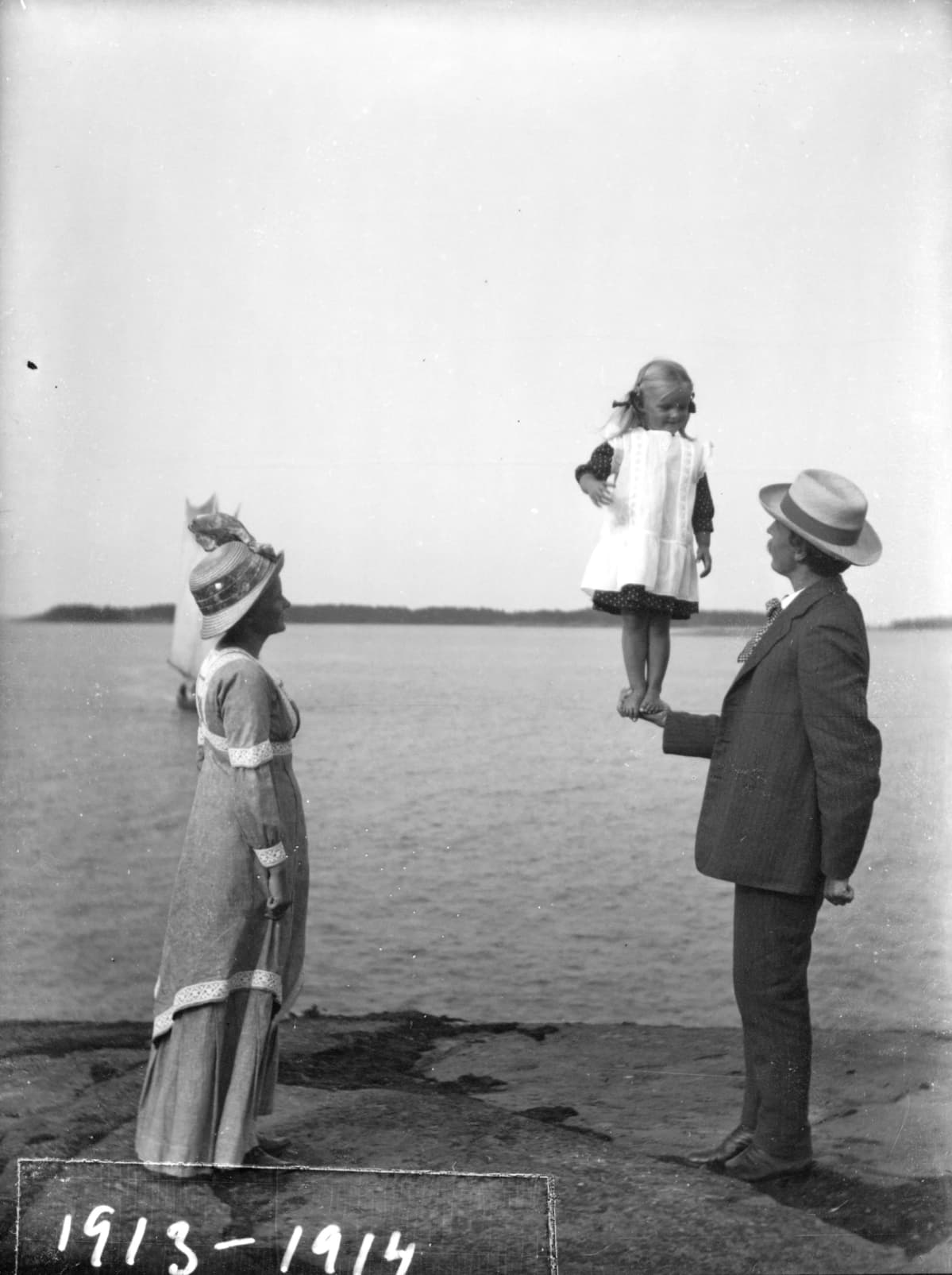 Tyttö seisoo isänsä kämmenellä