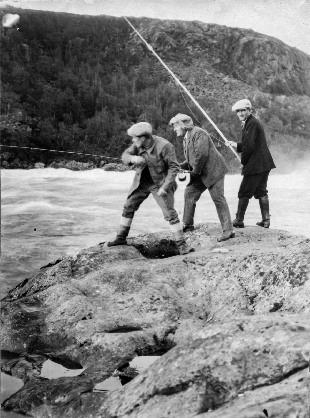 Kolme turistia kalastamassa Paatsjoen Kolttakönkään rantakalliolla, Petsamo kesällä 1924.