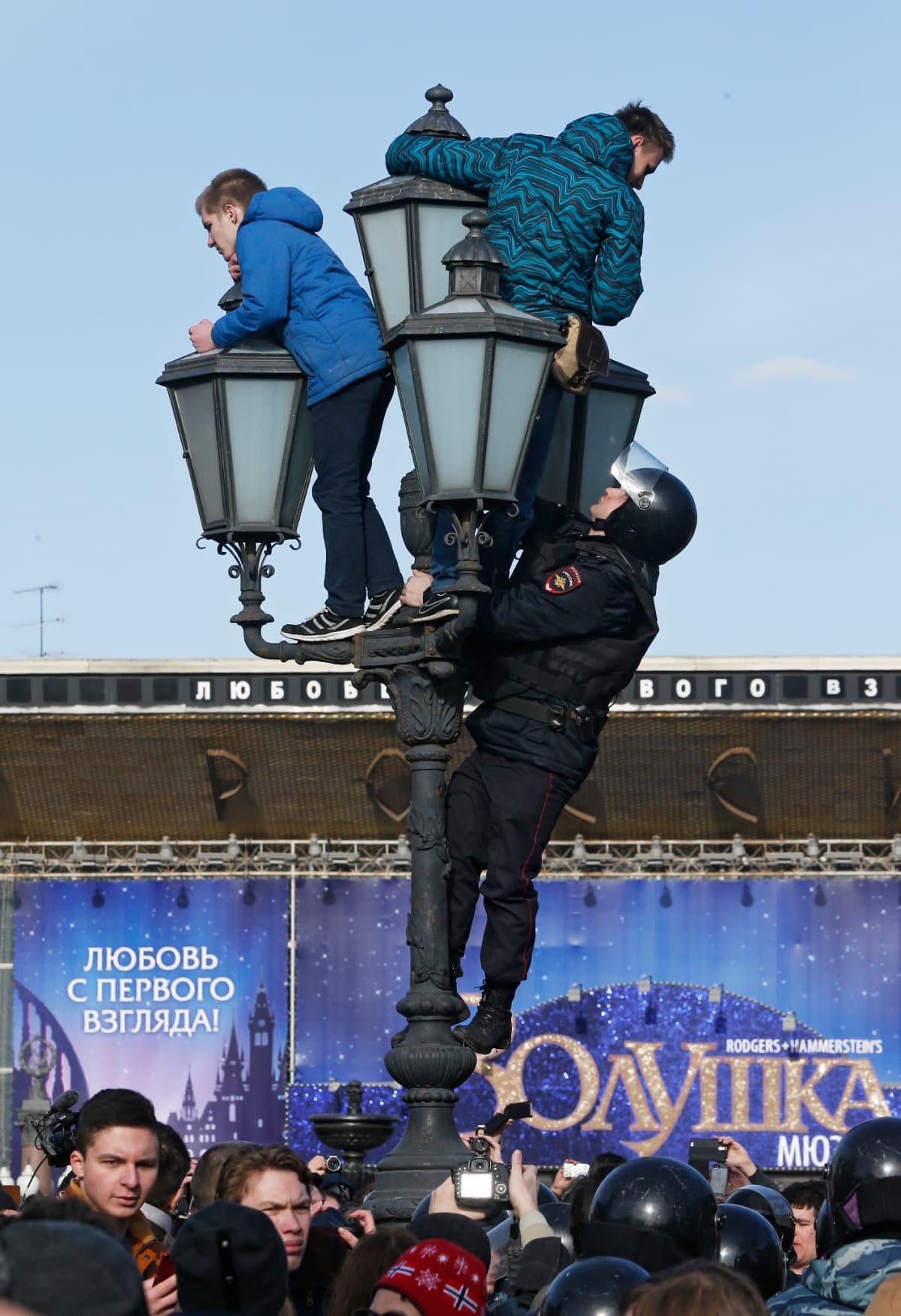 Erikoisjoukkojen poliisi kiipesi katulamppuun mielenosoittajien perässä sunnuntaina 26. maaliskuuta 2017.