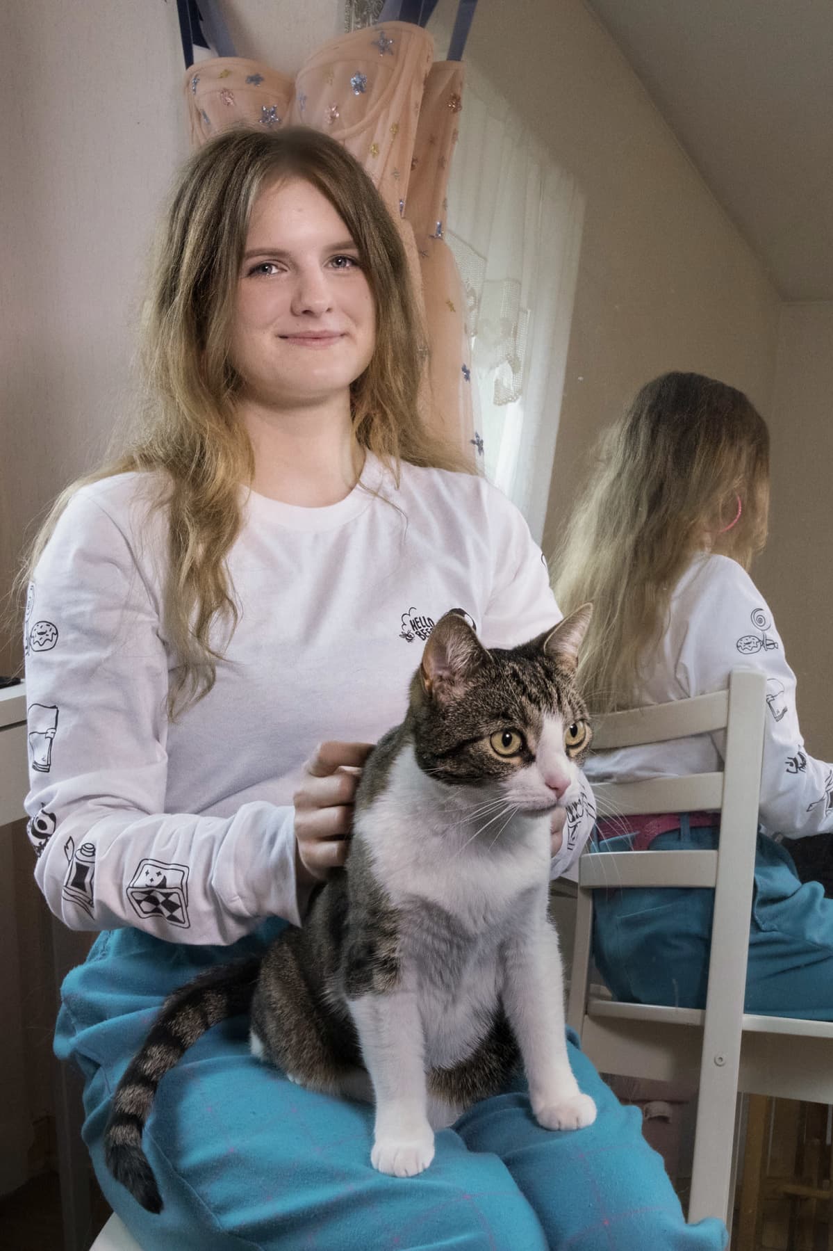 Muusa Pennanen istuu kissa sylissään.