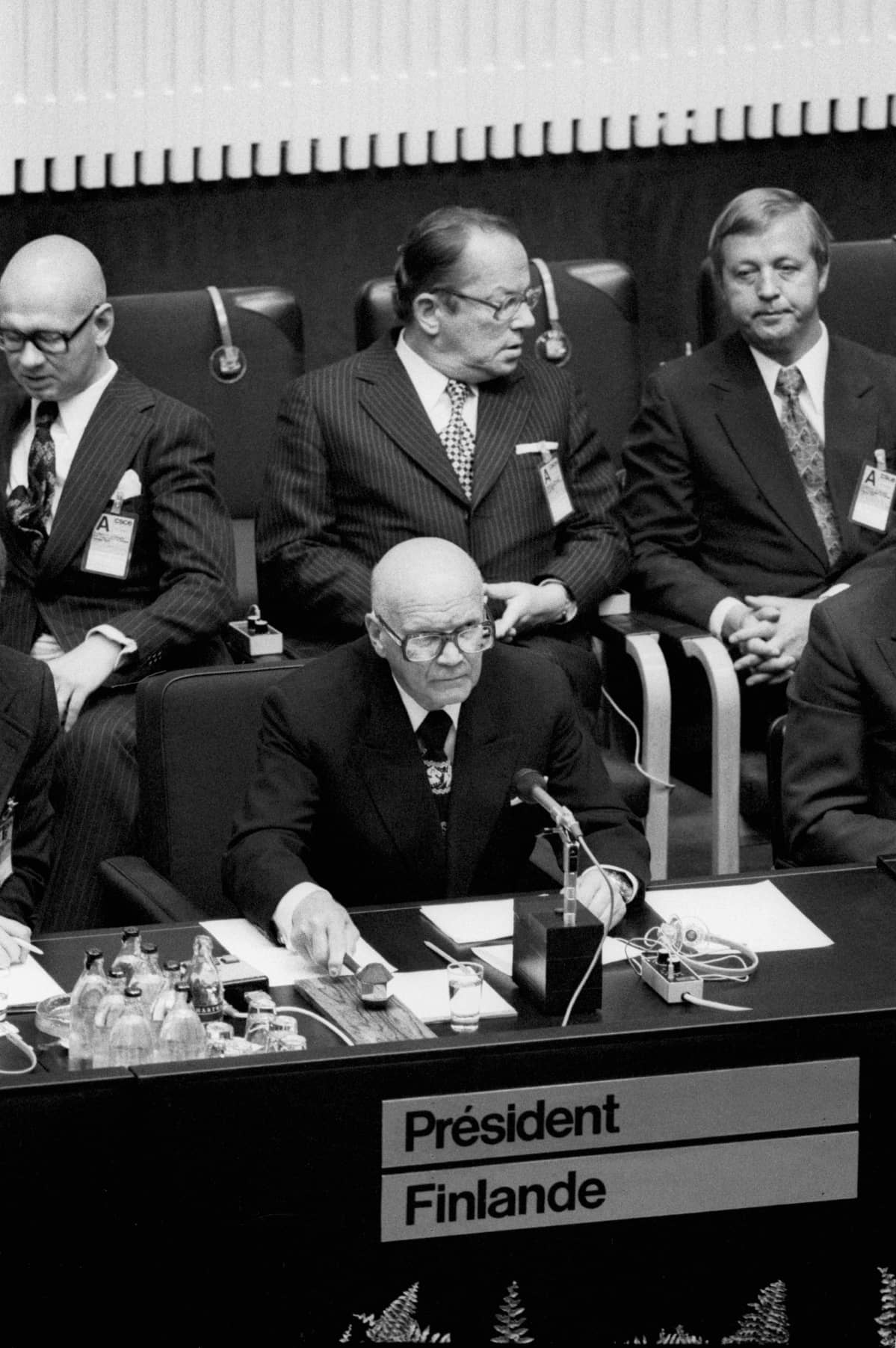 Euroopan turvallisuus- ja yhteistyökokouksen (ETYK) avajaiset Finlandia-talossa 31. heinäkuuta 1975. Presidentti Urho Kekkonen aloittamassa puhettaan, takarivissä Jaakko Iloniemi (vas.), Ahti Karjalainen ja Kalevi Sorsa.