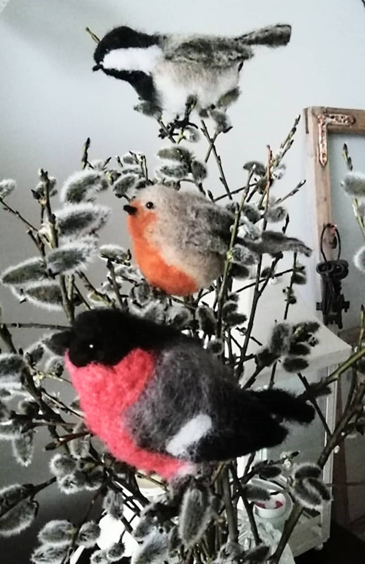 Huovutettuja lintuja oksissa pöydällä.