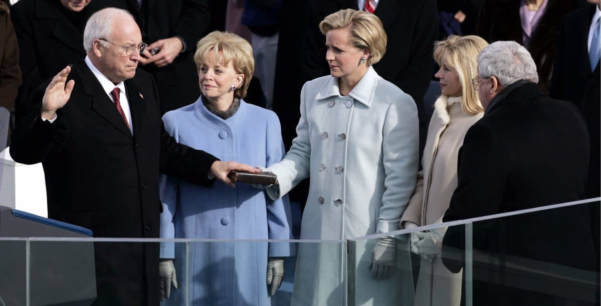 Dick Cheney vannoo virkavalaa toinen käsi kohotettuna ja toinen Raamatun päällä. Liz Cheney katsoo isäänsä.