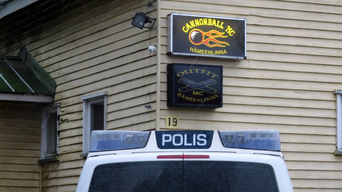 Seinällä kyltit Cannonball MC Hämeenlinna ja Outfit MC Hämeenlinna, etualalla poliisiauto