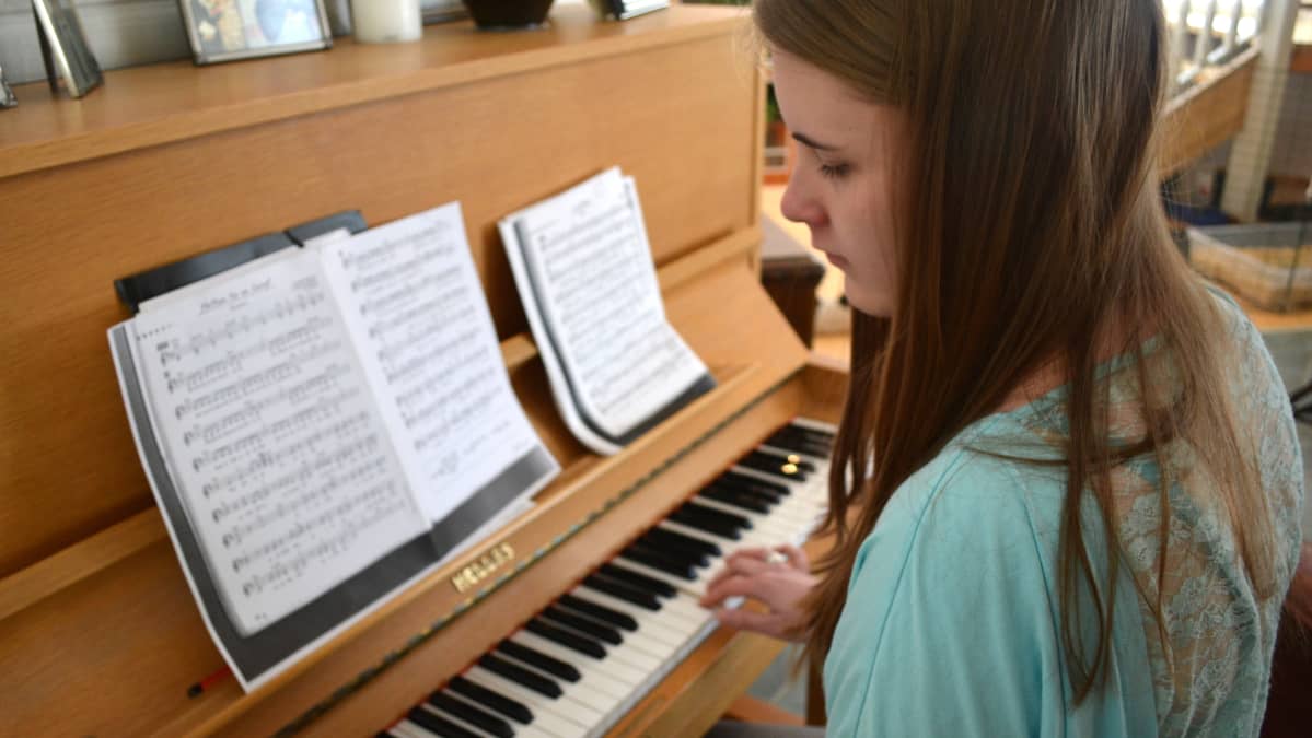 Vera Koponen soittaa kotonaan pianoa.