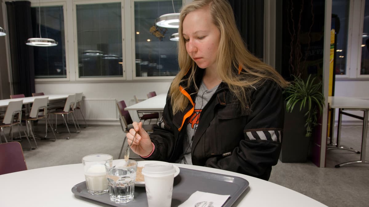 Opiskelija syö ruokalassa aamupuuroa.