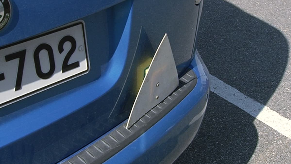 Opetuskolmio auton takapuskurissa.
