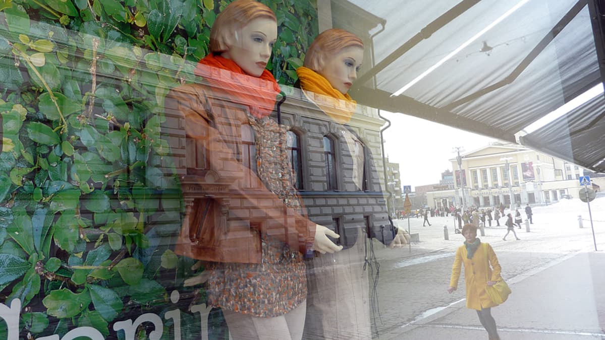 Näyteikkunassa kaksi mallinukkea puettuna värikkäisiin vaatteisiin