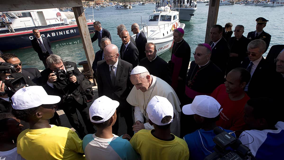 Paavi Franciscus tervehtii siirtolaisia vieraillessaan Lampedusan saarella.