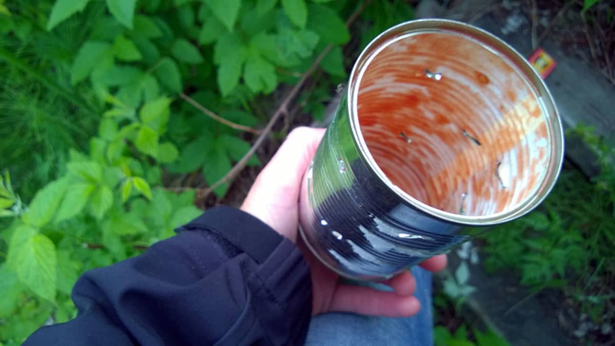 Tyhjä tomaattimurskapurkki, jonka sisällä palaa kynttilä