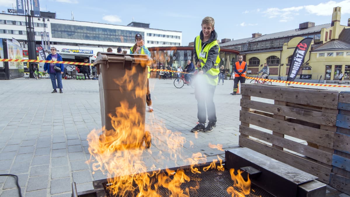 Koululainen sammuttaa tulipaloa pelastustaitokilpailussa.