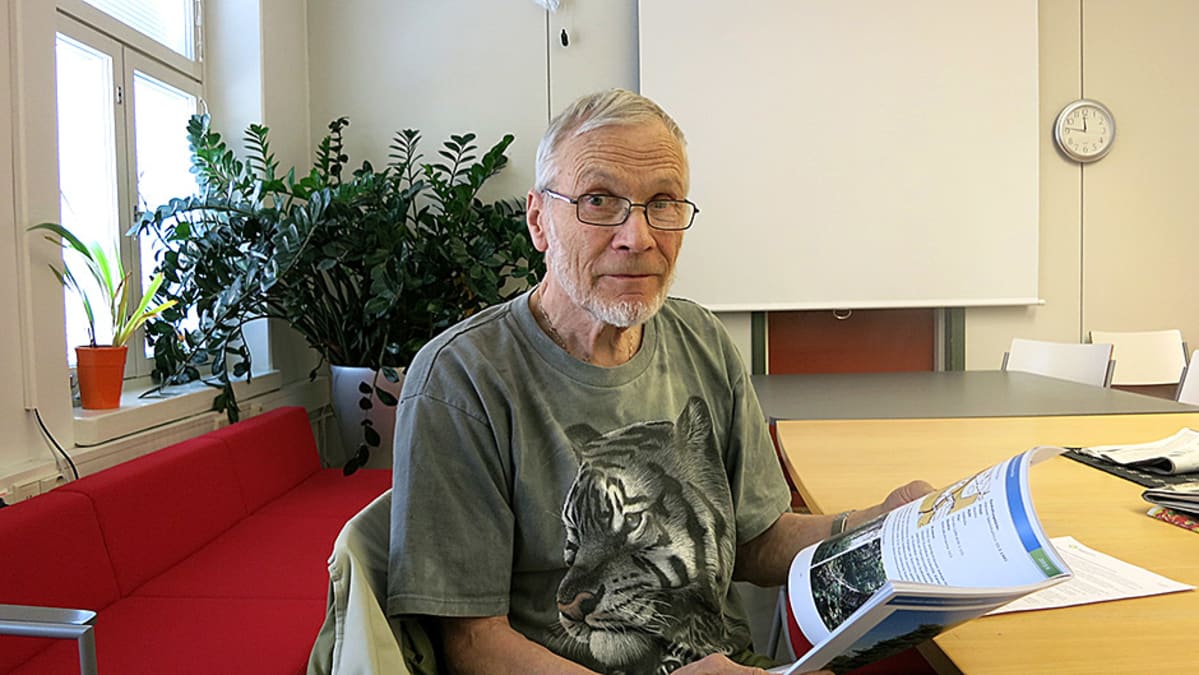 Juhani Kuusinen pitää kirjaa kädessään
