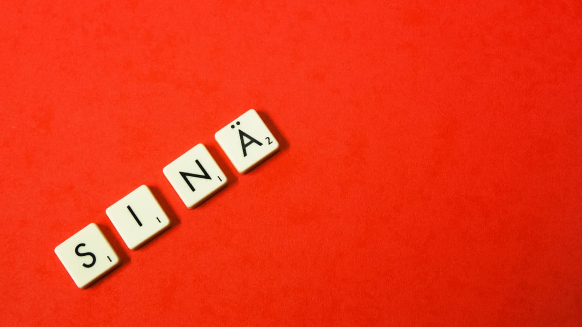 Teksti "sinä" punaisella pohjalla.
