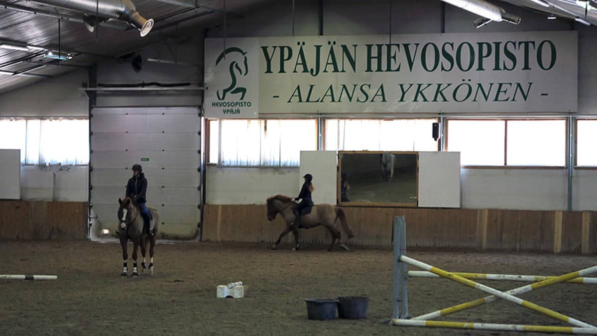 Esteratsastajia harjoittelemassa Ypäjän Hevosopiston ratsastusmaneesissa