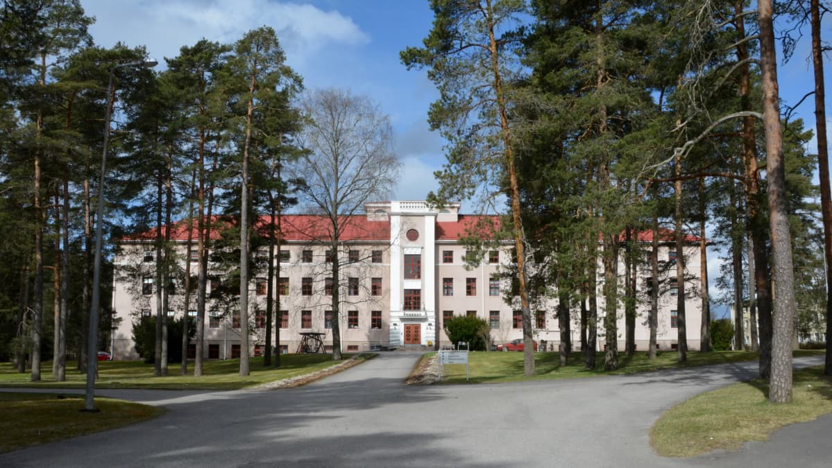 iso kivirakennus mäntyjen ympäröimänä